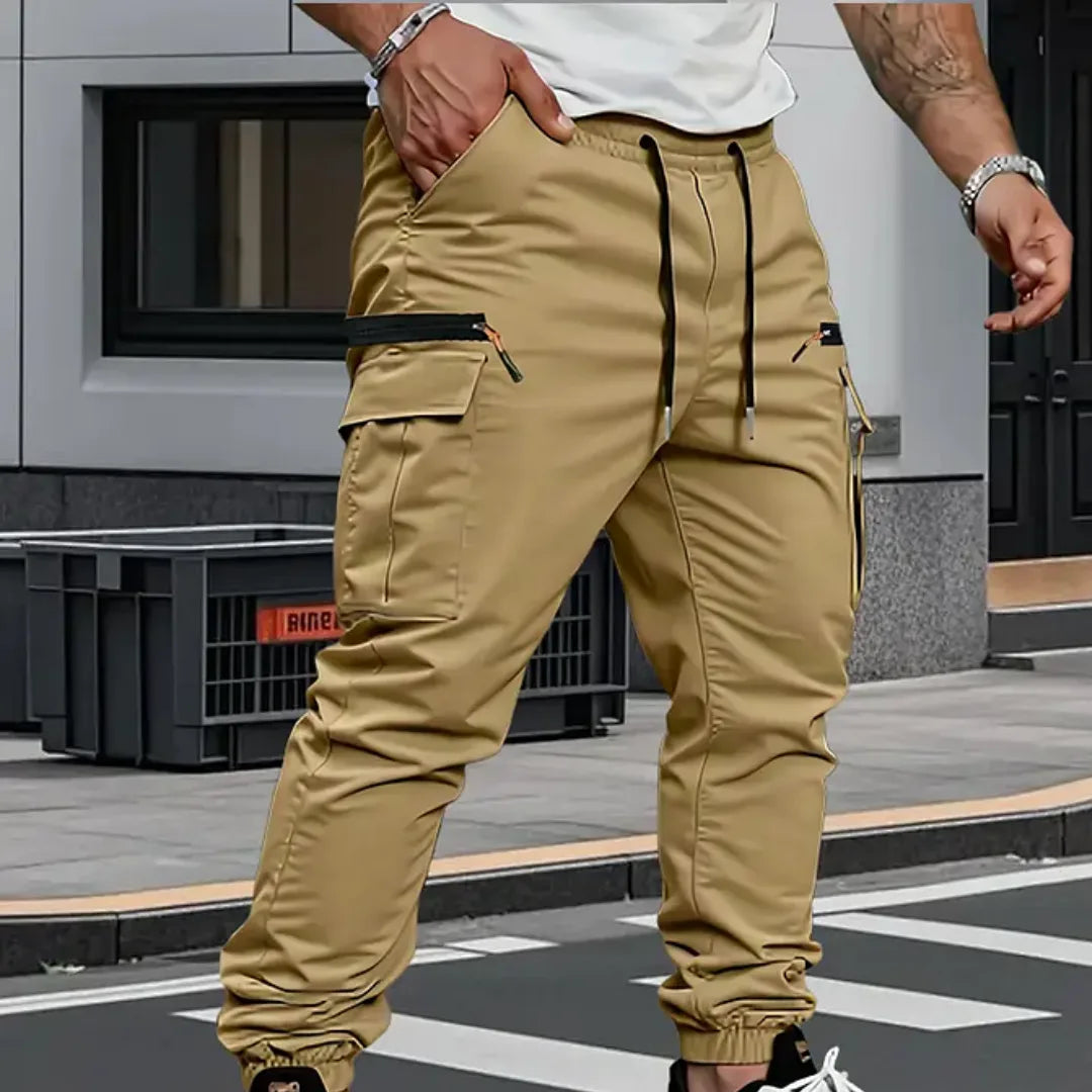 Khaki cargo trousers with visible stitching detail, drawstring waist and zip pocket on the thigh
