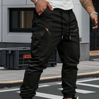 Black cargo trousers worn with white trainers, showing the elastic cuff and relaxed tapered fit