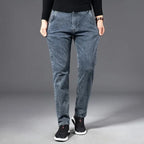 Man wearing slim blue-grey jeans with black jumper, front view showing tapered fit and zip fastening