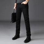 Man wearing slim black jeans with black jumper and boots, full-length front view of straight leg cut