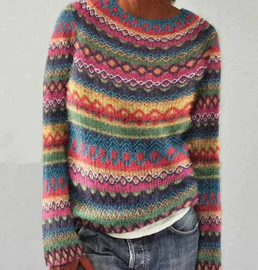 Detail view of a colourful fair isle patterned jumper showing diamond and zigzag knit motifs in pink, teal and mustard