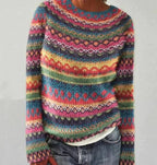 Detail view of a colourful fair isle patterned jumper showing diamond and zigzag knit motifs in pink, teal and mustard