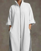 Close-up of the elasticated, striped trouser hem gathered above white trainers