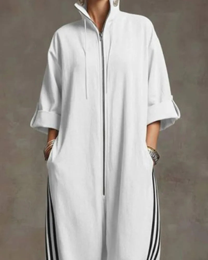 Close-up of the elasticated, striped trouser hem gathered above white trainers