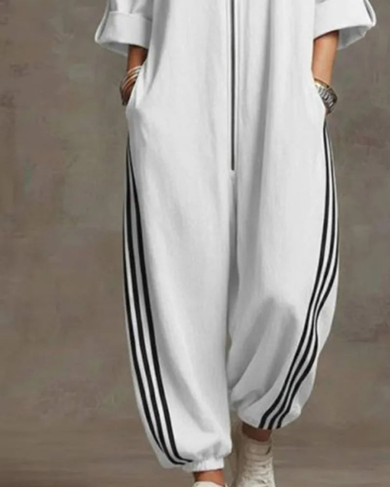 Close-up of the silver zip pull and drawstring toggles on the stand collar of the jumpsuit