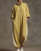 Front view of a woman wearing a mustard yellow oversized zip-front jumpsuit with striped wide-leg trousers