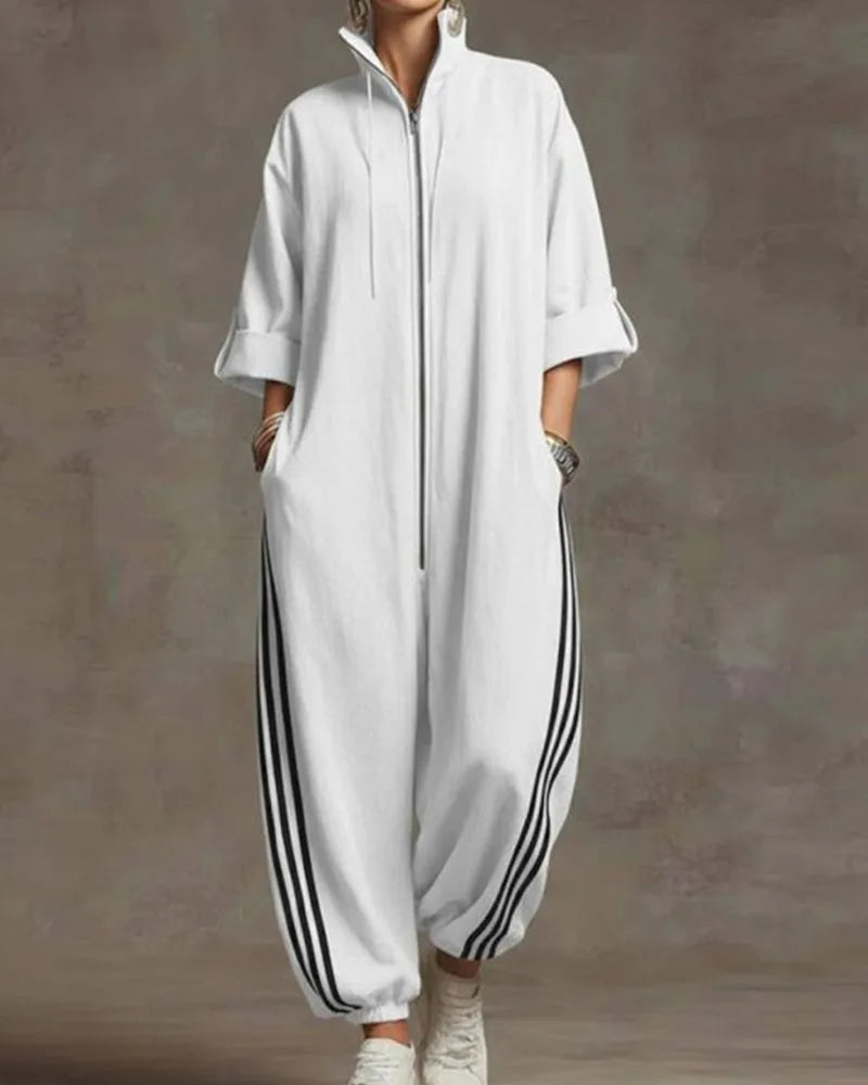 Full length front view of the mustard yellow jumpsuit paired with white high-top trainers