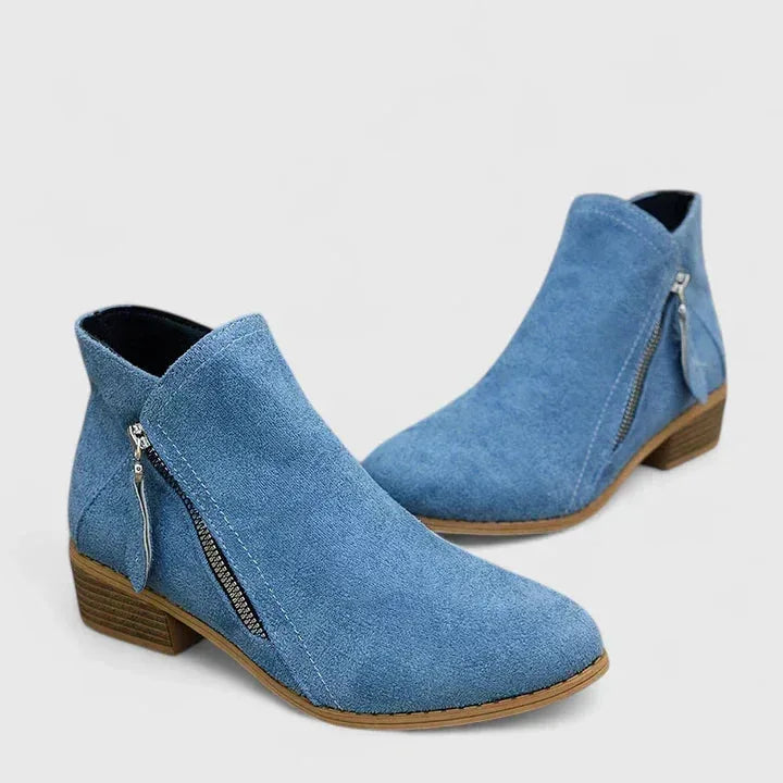 Pair of blue suede ankle boots shown together on a plain background, highlighting pointed toe and stitching