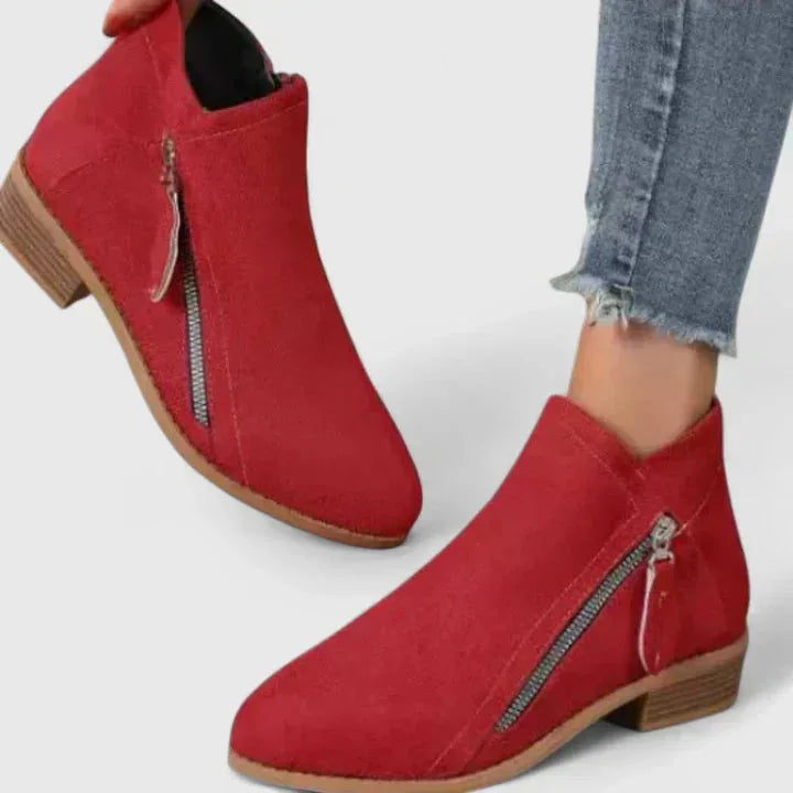 Pair of red suede ankle boots shown together, highlighting the pointed toe and contrast stitching
