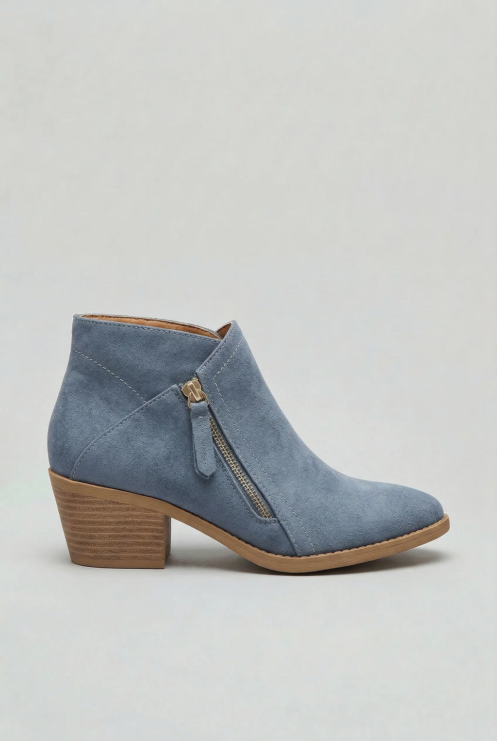 Side profile of a blue suede ankle boot with a gold-tone side zip and stacked block heel
