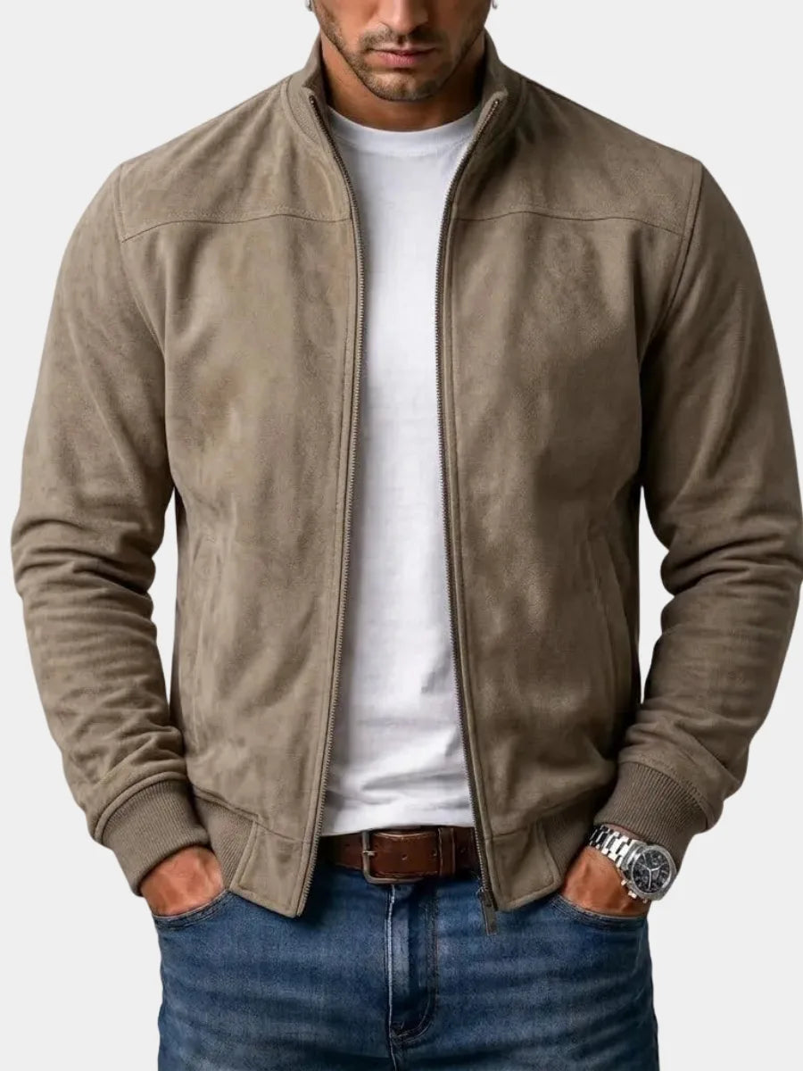 Man wearing an open khaki suede bomber jacket with stand collar over a white t-shirt and jeans