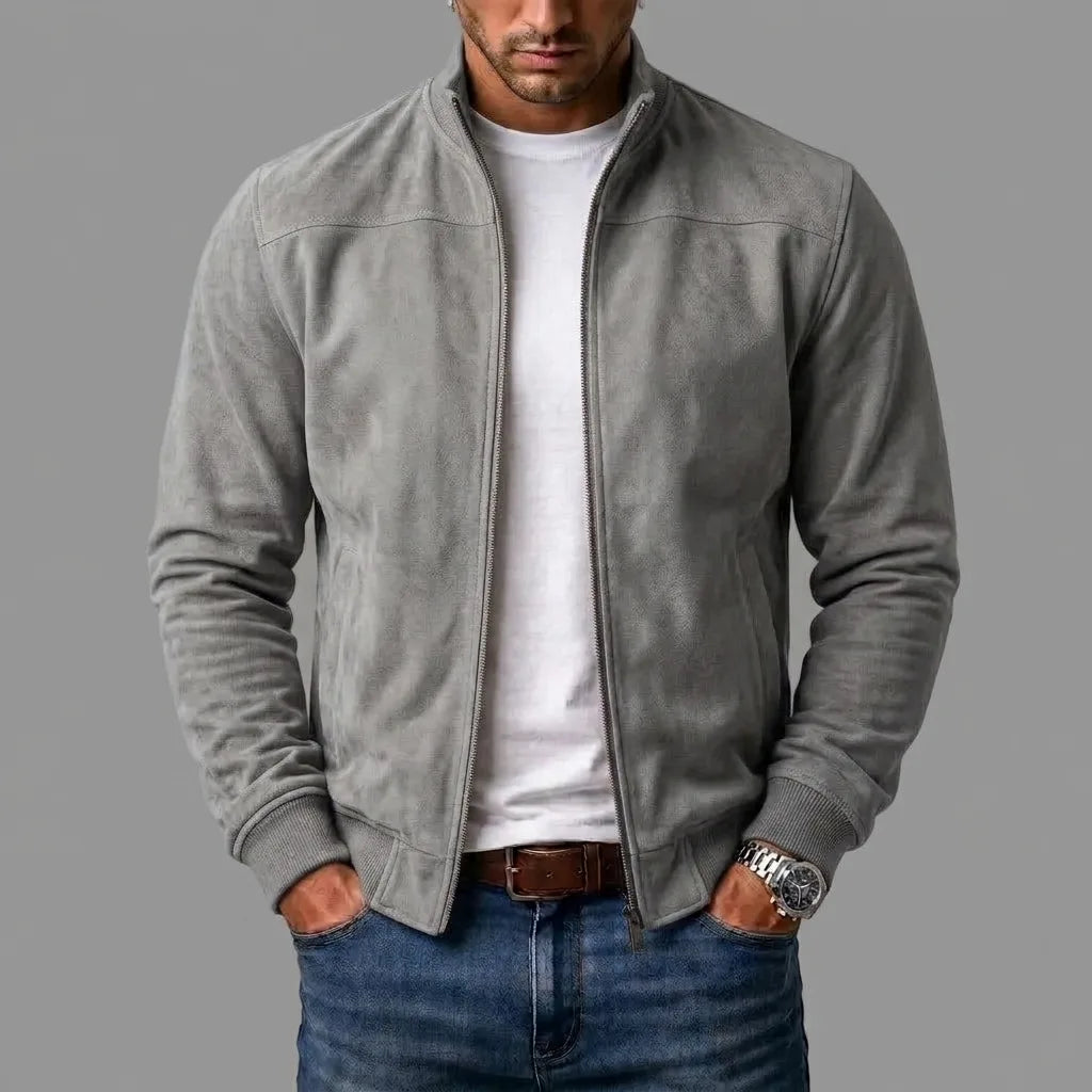 Grey suede bomber jacket worn open over a white t-shirt, hands in jean pockets