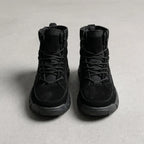 Front view of all-black suede combat boots with matching laces and canvas tongue panel