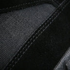 Close-up of black canvas and suede stitching detail on the boot's upper construction
