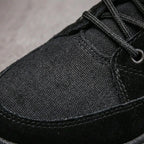 Close-up of the black fabric eyelets, laces and toe cap stitching on the boot upper