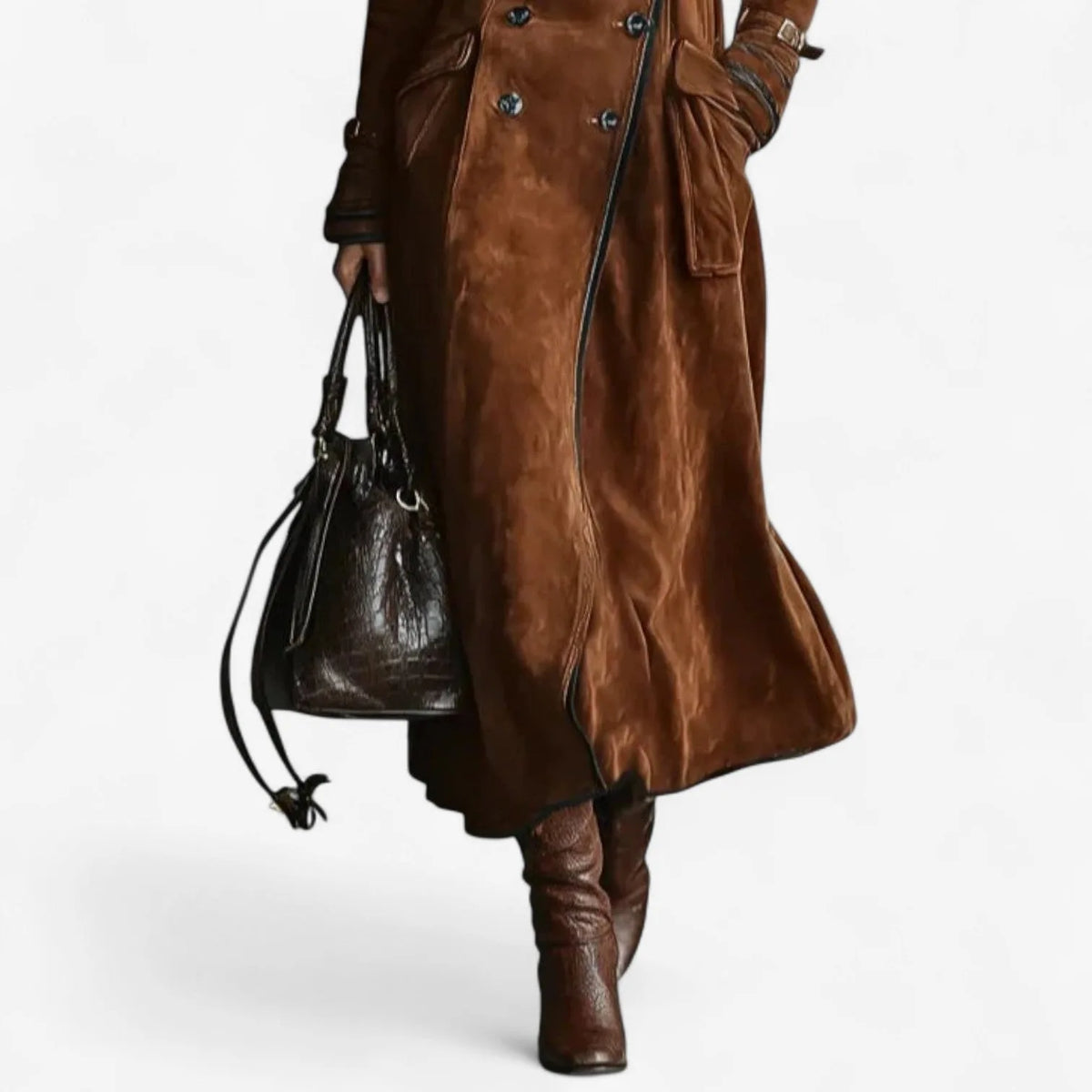 Close-up of the suede coat's flared hem and piped edge over tall brown leather boots