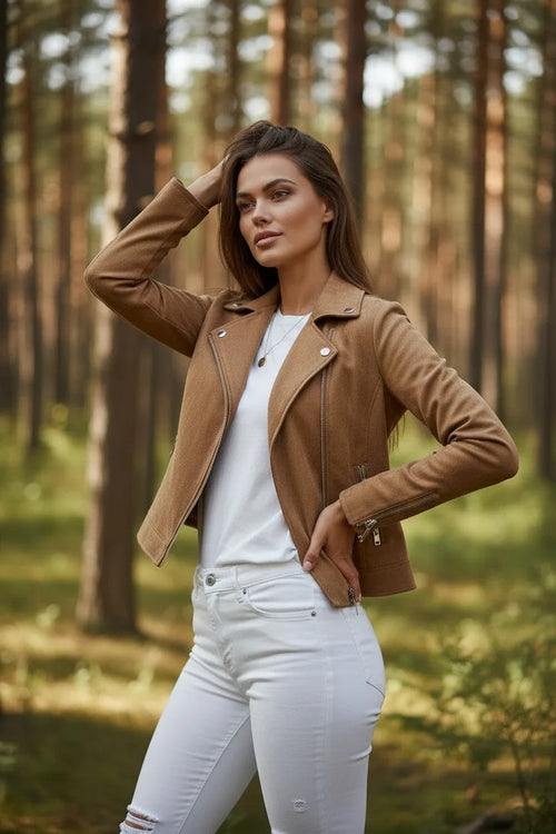 Woman wearing an open tan suede-effect biker jacket, hand in hair, showing the collar and front zip detail.