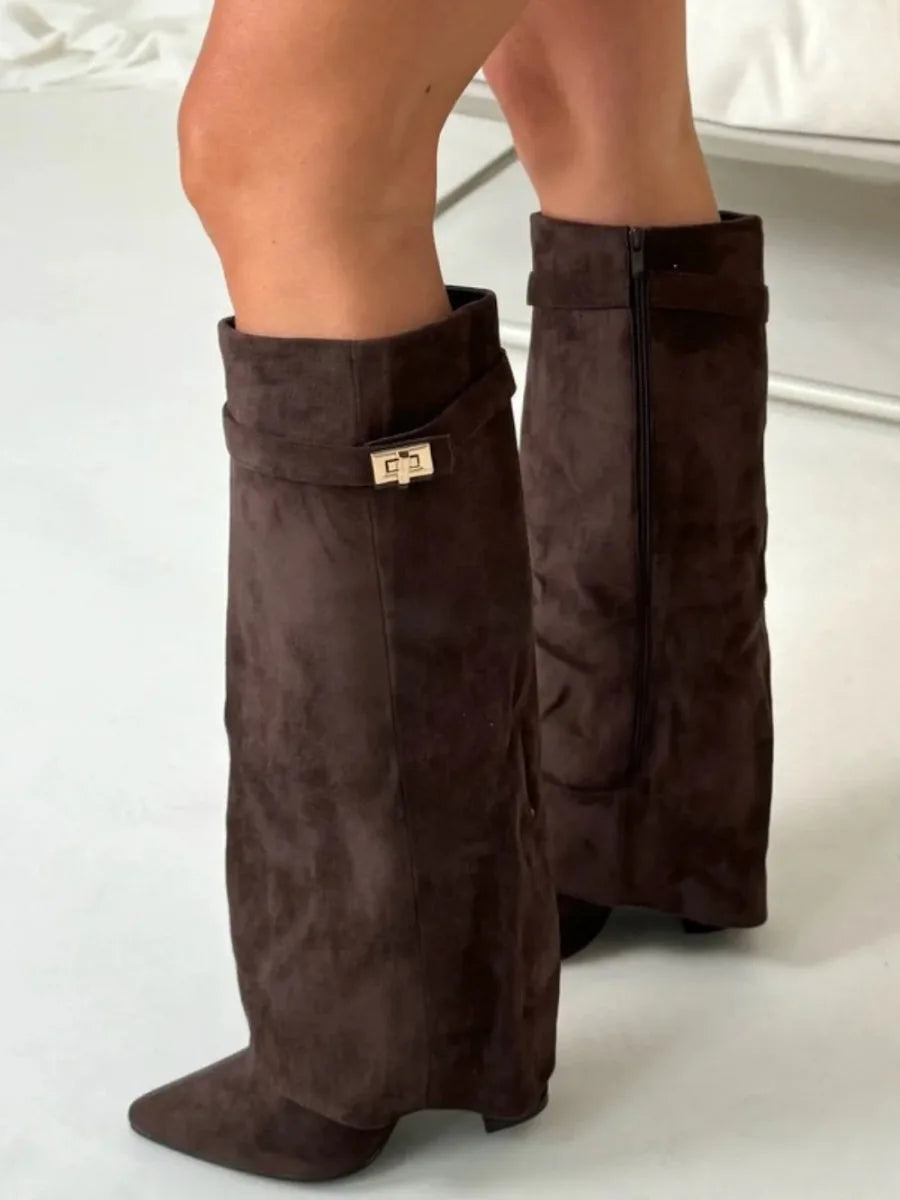 Side view of dark brown suede fold-over boots seated pose showing the pointed toe and heel