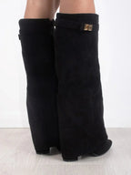 Back view of black suede fold-over boots highlighting the side zipper and gold buckle strap