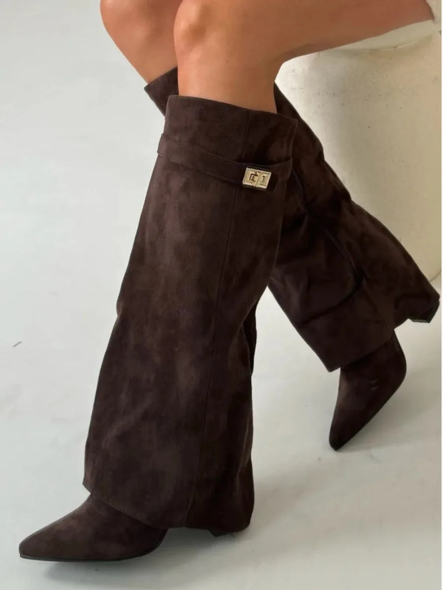 Close-up side view of beige suede boot cuff with gold buckle and visible side zip