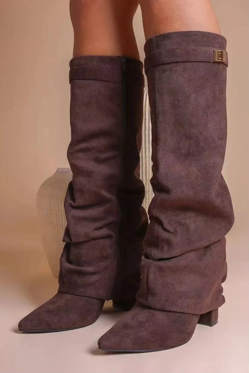 Close-up of legs wearing brown suede-effect slouchy boots, one shown with side zip fastening