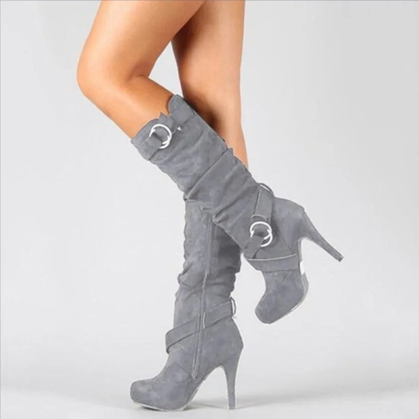 Side view of grey suede knee-high stiletto boot with slouched shaft and two ring buckle straps