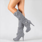 Side view of grey suede knee-high stiletto boot with slouched shaft and two ring buckle straps