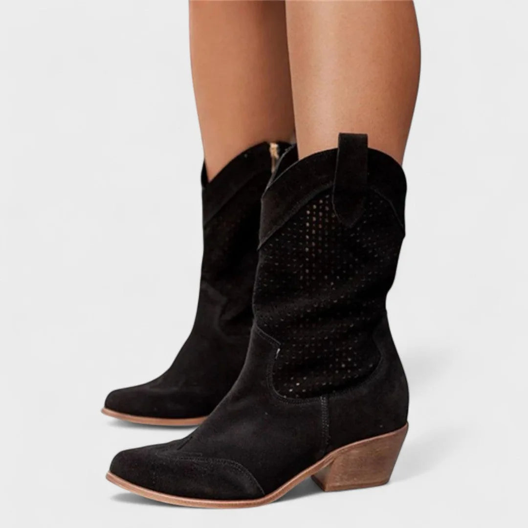Close-up side profile of white leather western-style boot with scalloped perforated panel and low heel