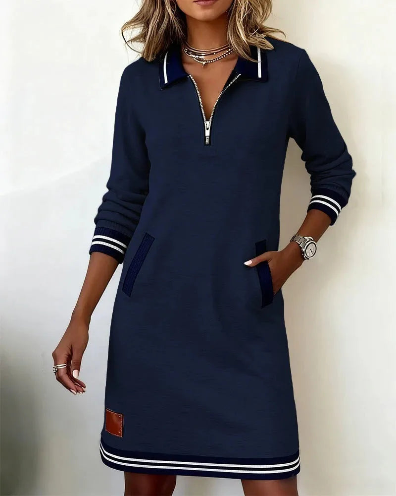 Camel-toned sweatshirt dress shown from the front, highlighting the zip neckline and ribbed navy cuffs