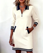 Cream sweatshirt dress detail shot showing the leather-look patch near the hem and striped ribbed trim