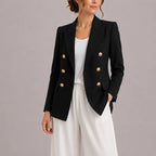 Black double-breasted blazer with gold-tone buttons and peak lapel, worn open over a white top