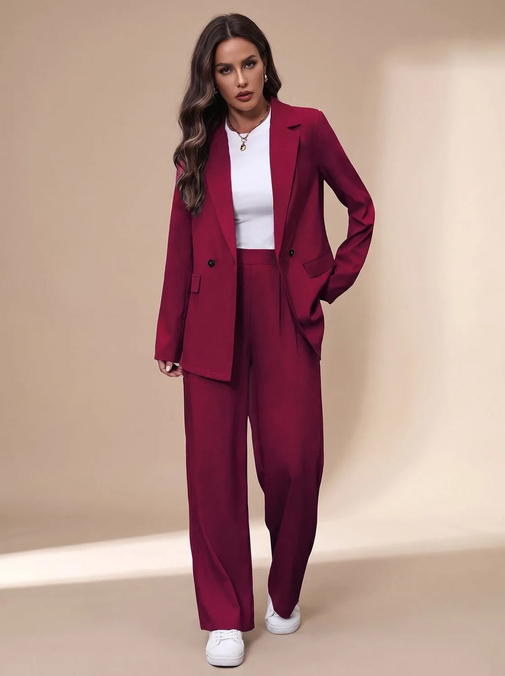 Woman wearing a burgundy double-breasted blazer and wide-leg trousers with a white top, hand in pocket
