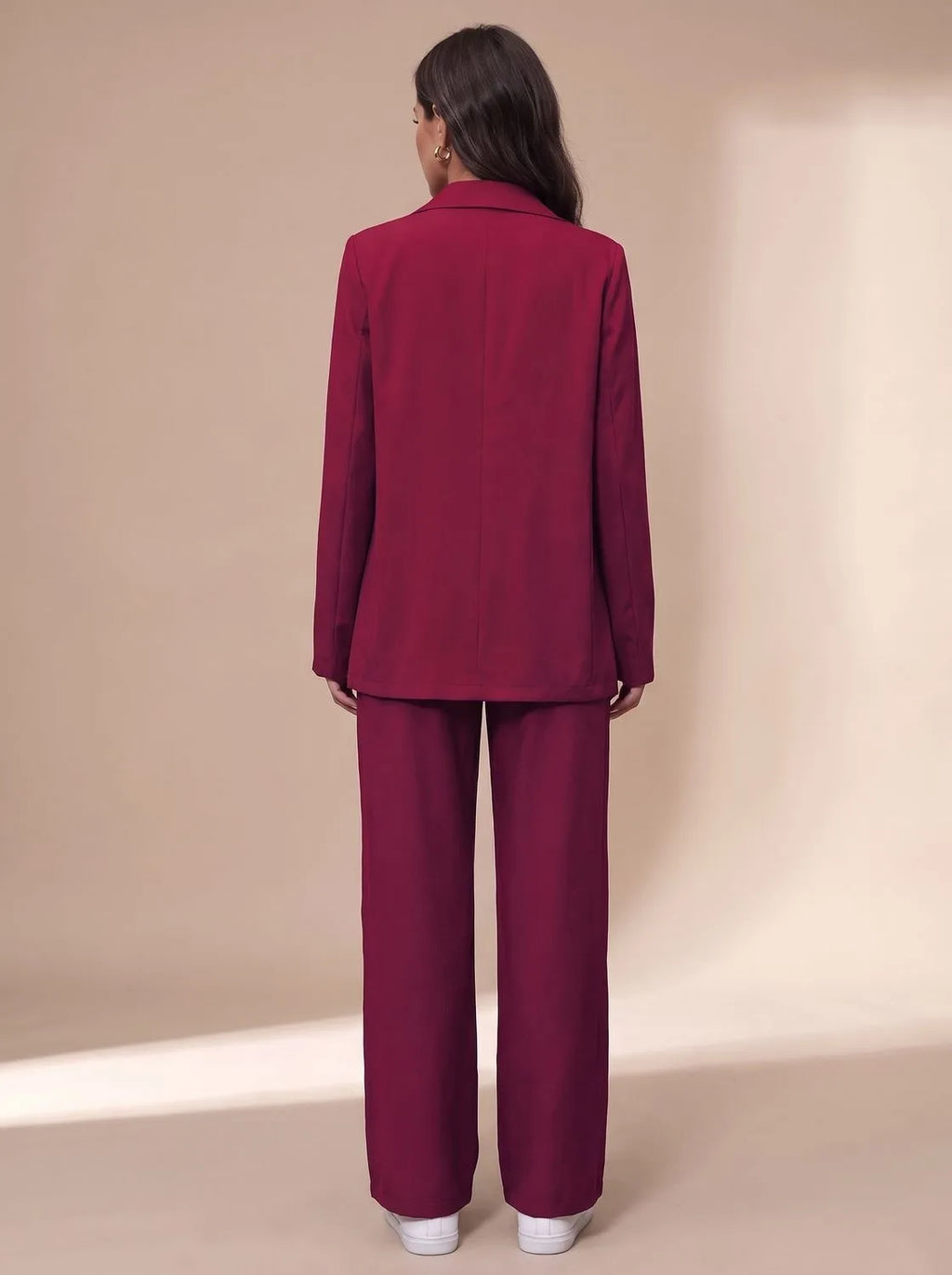 Back view of the burgundy blazer and wide-leg trousers showing the fitted waist seam and straight hem