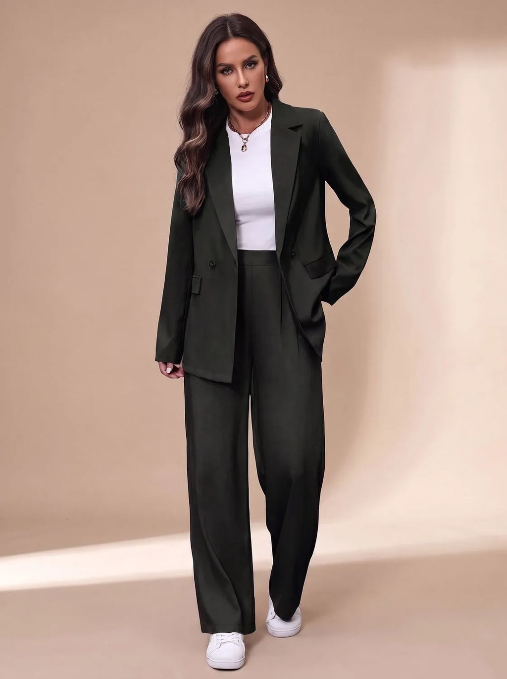 Model in a dark green double-breasted blazer and matching wide-leg trousers with a white top underneath