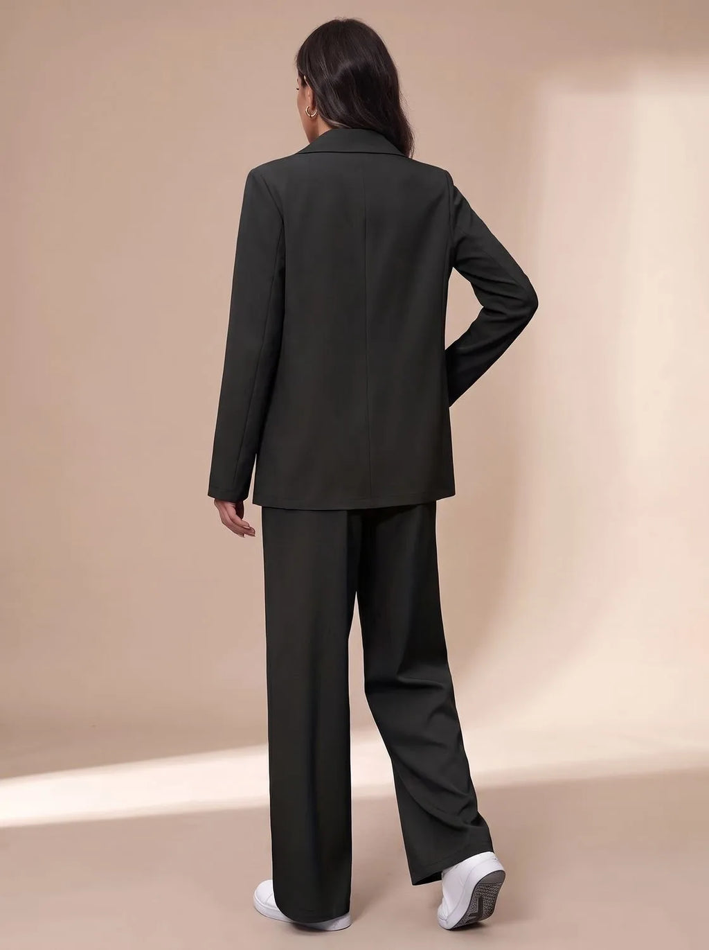 Back view of the dark green blazer and trousers showing the tailored fit through the shoulders and back