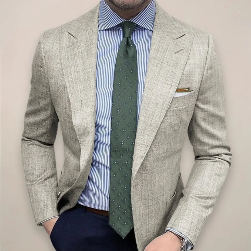 Close-up of a man in a beige textured blazer worn with a striped blue shirt and green patterned tie