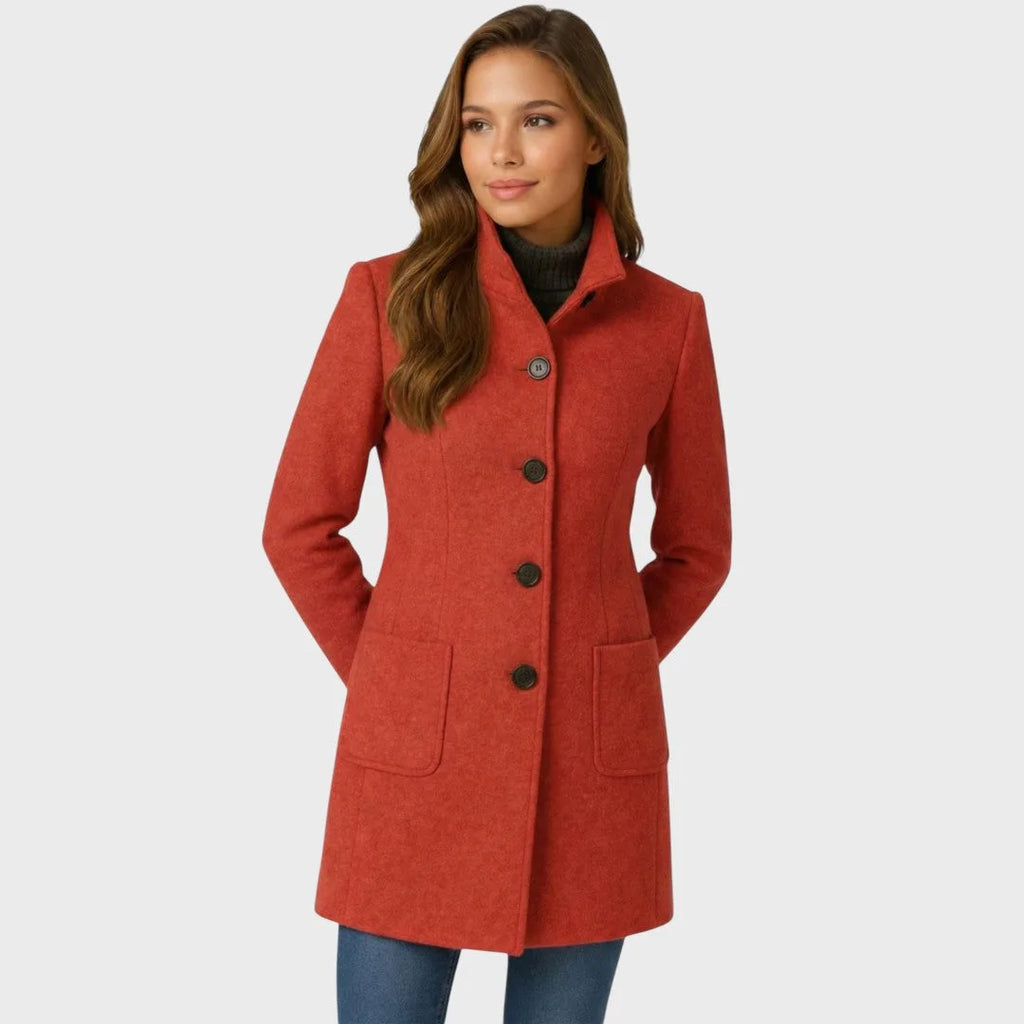 Rust red wool coat with stand collar and four-button front, shown buttoned up over a dark polo neck