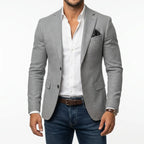 Grey woven tailored blazer worn open over a white shirt, showing textured fabric and notch lapel detail