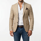 Beige tailored blazer with patterned pocket square, buttoned front and flap pockets shown close up