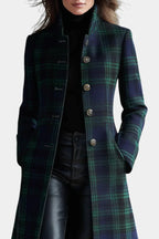 Close-up of the stand collar, ornate metal buttons and tartan pattern on the coat's bodice