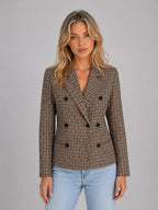 Front view of a taupe checked double-breasted blazer worn open over jeans, showing lapel collar and button detail