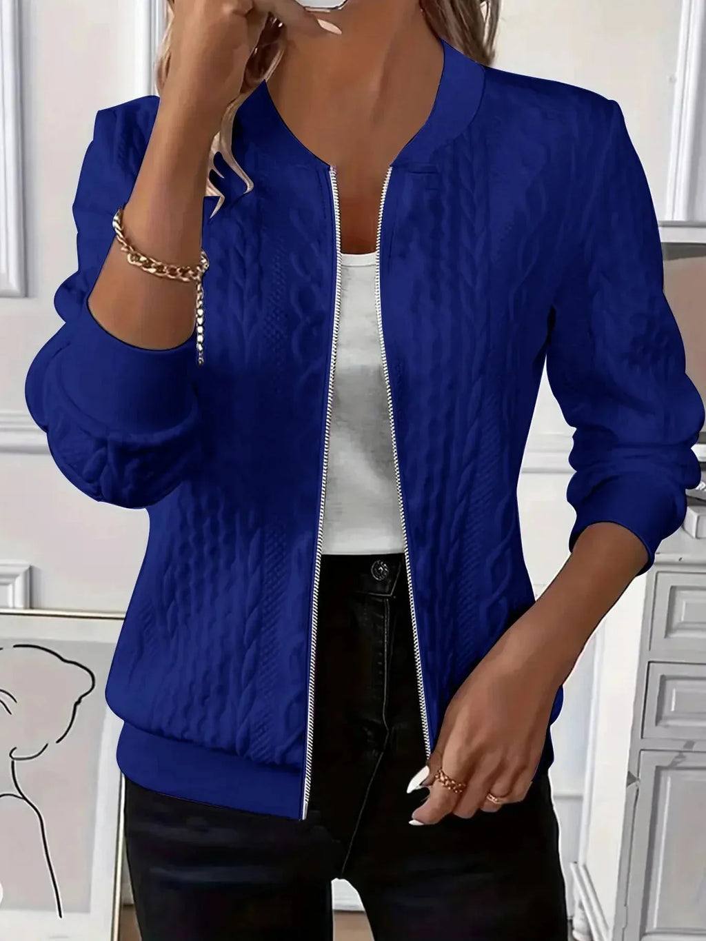 Model wearing white textured bomber jacket from the back, paired with light denim jeans