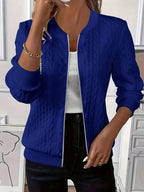Model wearing white textured bomber jacket from the back, paired with light denim jeans