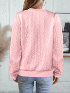 Back view of pink textured bomber jacket highlighting cable knit design and ribbed cuffs