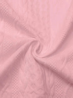 Close-up of pink textured fabric swirled to display the raised cable knit pattern in detail