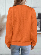 Back view of orange textured bomber jacket showing cable knit texture running across the back panel