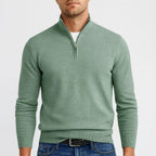 Sage green quarter-zip jumper with ribbed stand collar, layered over a white t-shirt and belted jeans