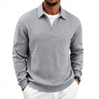Light grey textured quarter-zip pullover worn with white trousers, front view showing collar and zip