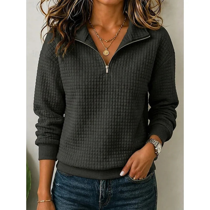 Close-up of the ribbed stand collar and zip detail paired with layered necklaces