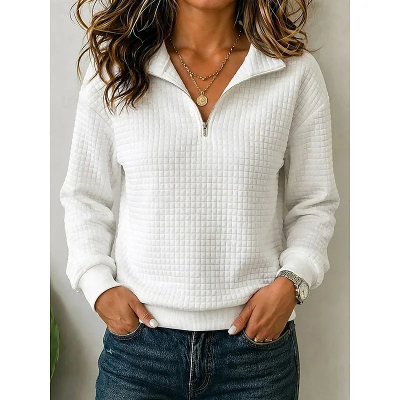 Front view of a white textured quarter-zip pullover worn with dark denim jeans
